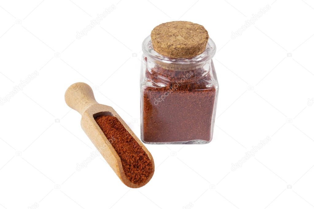 Tandoori Masala mix of spices in wooden scoop and glass jar on isolated on white background. Spices and food ingredients.