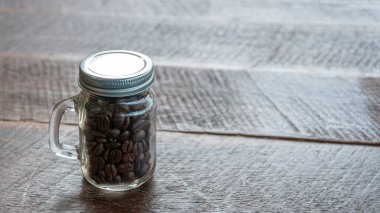 Eski ahşap zeminli cam şişelerde kahve çekirdekleri.