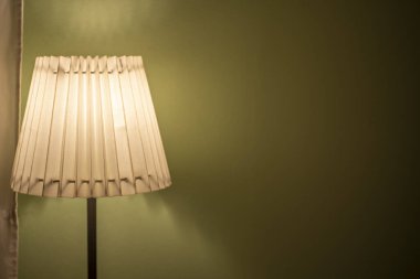 Gece mobilyalarında yeşil duvarı olan lamba.