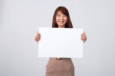 Female thai teacher in uniform standing with white background holding a big  white paper to to the front