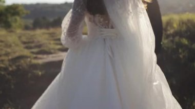 Gelin ve damat yürüyüşü. Düğün gününün tadını çıkarıyorum. Hayatın mutlu anları. Yeni evliler el ele tutuşur. Gelinlik giymiş güzel bir gelin. Gerçek duygular