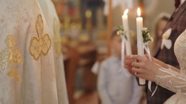 Gelin ve damat kilisede Hıristiyanlık nikahında ellerinde mumlarla duruyorlar. Bir erkekle bir kadının düğün bağı. Yeni evliler
