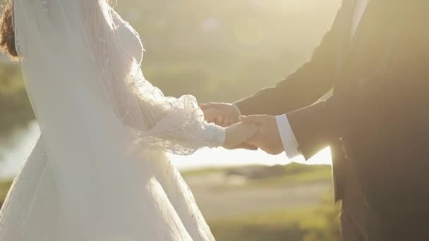 ใกล้ชิดชายหนุ่มและหญิงที่จําไม่ได้จับมือกัน คู่สมรสใหม่ที่ไม่รู้จักยืนหลังจากการแลกเปลี่ยนแหวน คู่แต่งงานที่มีความสุข ความสัมพันธ์ที่โรแมนติก ชุดสีขาว — วีดีโอสต็อก