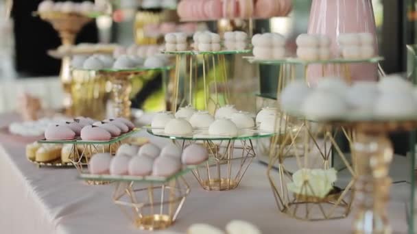Красивый яркий шведский стол со множеством сладких закусок, шоколадный батончик на белом столе и ждет гостей на празднике. Свадебная выпечка на зеркальном лотке. Сладкие конфеты на столе — стоковое видео