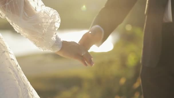 Blízká Nevěsta a Ženich se drží za ruce. Novomanželé stojí po výměně prstenů. Šťastný svatební pár. Romantický vztah. — Stock video