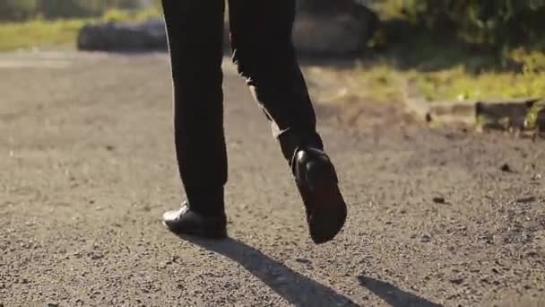 スタイリッシュなビジネスマンの足夏の日にレジャーウォーキング。仕事に通勤するビジネスマンの後ろ足。革の靴を履いた男が自信を持って向かっている。おしゃれなビジネスマンが通りを歩く. — ストック動画