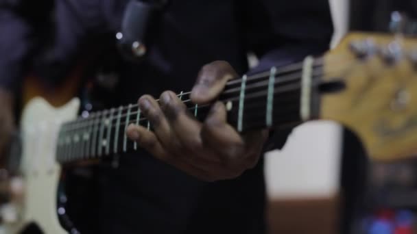 Músico tocando guitarra durante uma apresentação ao vivo. A tocar guitarra. Strumming guitarra elétrica. Um músico toca música. Mãos humanas a tocar guitarra eléctrica. Dedos nas cordas da guitarra. — Vídeo de Stock