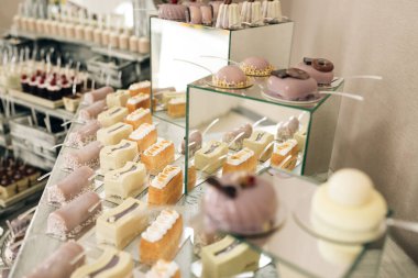 Ayna tepsisindeki düğün pastaları. Masada şeker var. Güzel, parlak bir büfe, bir sürü tatlı atıştırmalık beyaz bir masada bir çikolata ve kutlama için misafirleri bekliyor.