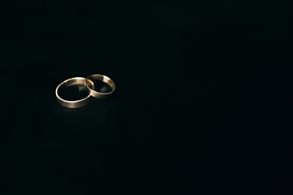 Dos anillos de boda sobre fondo negro — Foto de Stock
