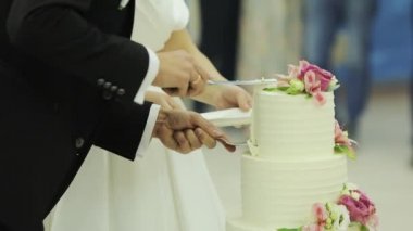 Düğün pastasını kes. Gelin ve damat düğün pastasını kesti. Yeni evlilerin kestiği düğün pastasının ayrıntıları