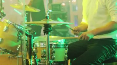 Çalarken davullar ve ziller. Bateri seti, davul seti karanlıkta, davulcu bir konser veriyor. Davulcu ıslak davula vurdu. Genç adam sahnede davul çalıyor. Konser. Neon ışığı
