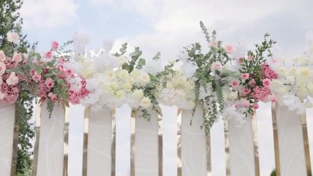 Piękny wystrój ślubny. Łuk ślubny ze świeżymi kwiatami w słoneczny letni dzień ślubu. Dekoracje ślubne z kwiatami w Sali Restauracyjnej — Wideo stockowe