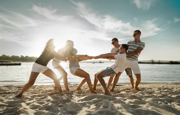 Amigos Divertido Tirón Guerra Playa Bajo Luz Del Sol Puesta —  Fotos de Stock