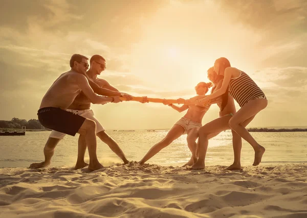 Amigos Divertido Tirón Guerra Playa Bajo Luz Del Sol Puesta —  Fotos de Stock