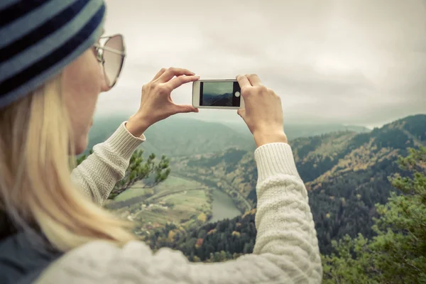 Mulher fotografando vista da natureza nas montanhas — Fotografia de Stock