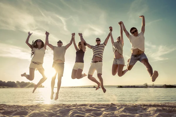Amici Che Saltano Sulla Spiaggia Sotto Luce Del Sole Del — Foto Stock