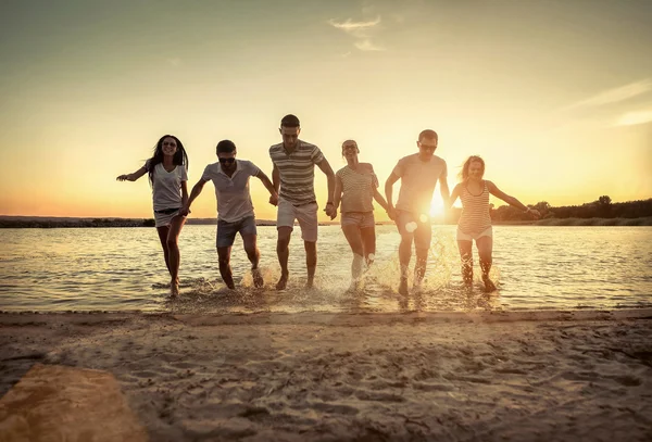 Sahildeki bir grup gencin silueti..