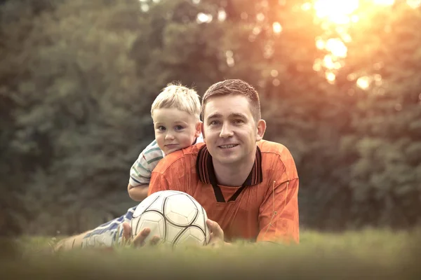 Far och son spelar fotboll — Stockfoto