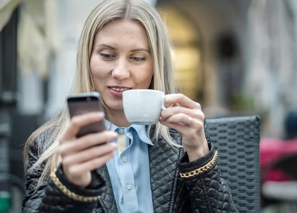 Woman with phone and coffee in cafe — Stock Photo, Image