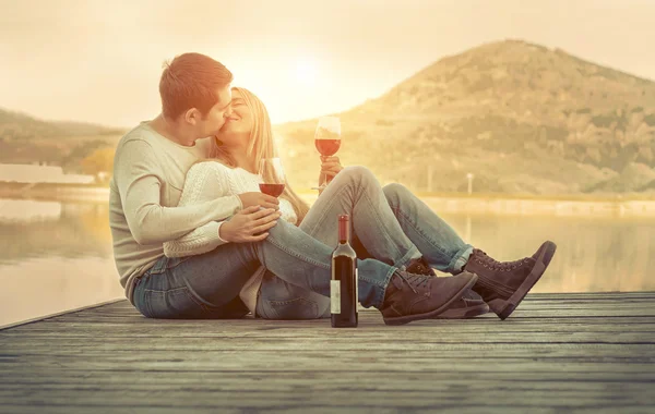 Para siedzi na molo z czerwonego wina Obrazek Stockowy
