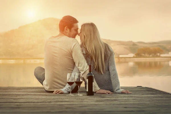 Casal sentado no cais com vinho tinto Fotografia De Stock