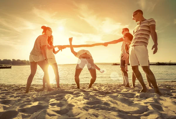Φίλοι Αστείο Παιχνίδι Στην Παραλία Κάτω Από Ηλιοβασίλεμα Φως Του — Φωτογραφία Αρχείου