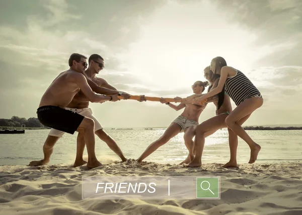Друзья Веселые Перетягивания Каната Пляже Закатом Солнца — стоковое фото