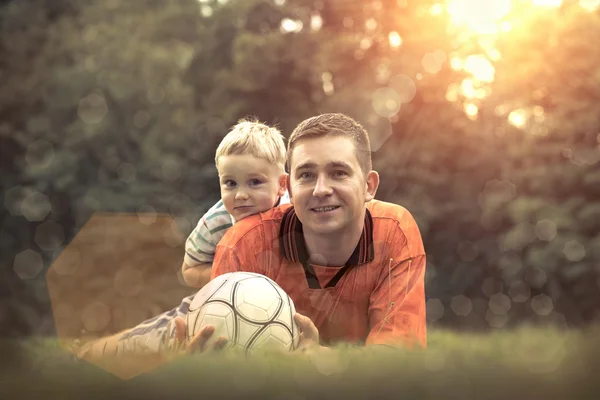 Far og sønn spiller fotball. – stockfoto