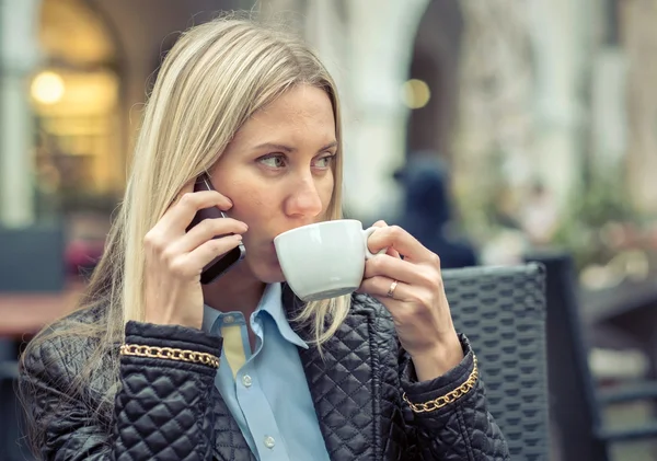 Žena s telefonem a kávu v kavárně — Stock fotografie