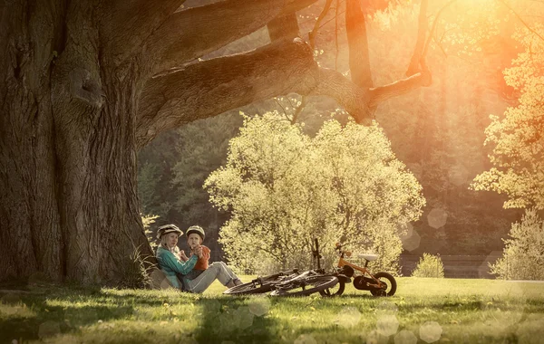 Mother and son with bicycles in the park — Stock Photo, Image