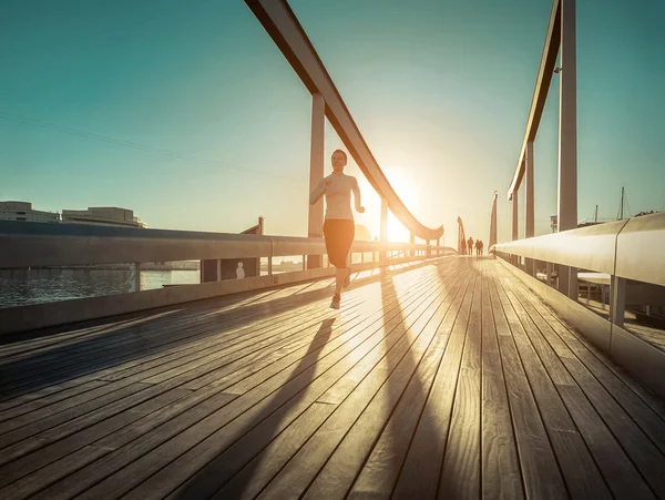 Frau läuft auf Brücke — Stockfoto