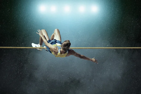 Athlete in action of high jump — Stock Photo, Image