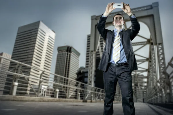 Businessman on bridge with phone — Stock Photo, Image