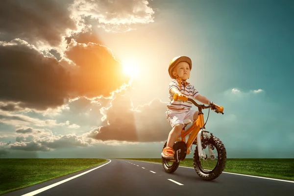 Kind op oranje fiets — Stockfoto