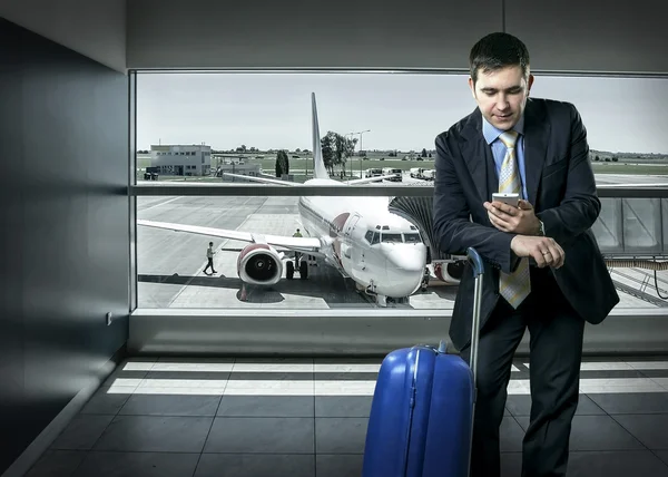 Geschäftsmann mit Gepäck im Flughafen — Stockfoto