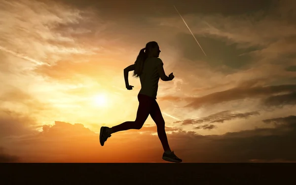 Beautiful silhouette of female running — Stockfoto