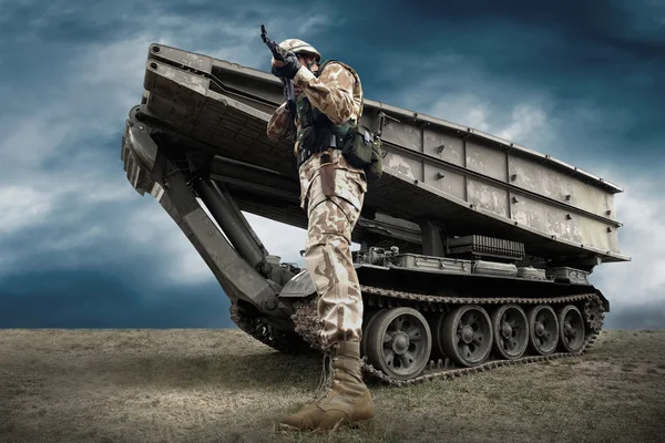 Militära tank och soldat utomhus. Stockbild