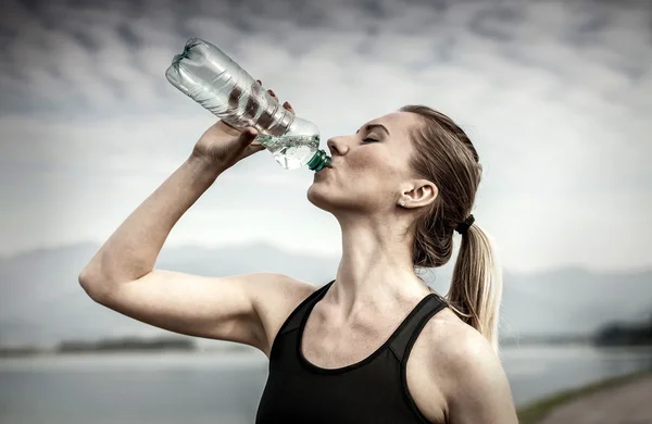 Женщина пьет воду после бега — стоковое фото