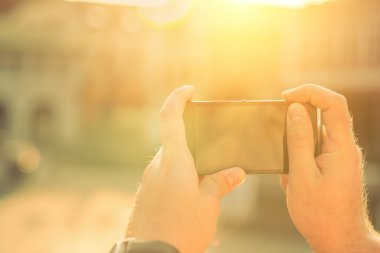 Telefon güneş ışığı altında olan adam