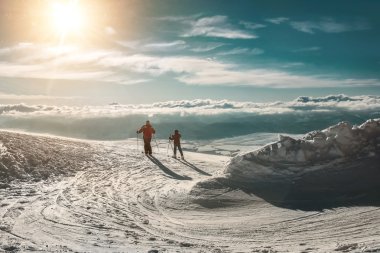 Dağ tepe üzerinde iki kayakçı