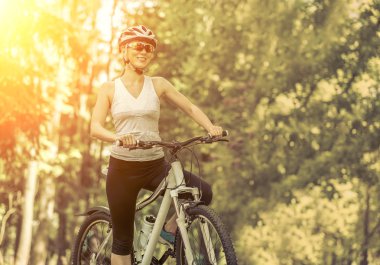 kadın parkta bisikletle.