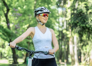 kadın parkta bisikletle.