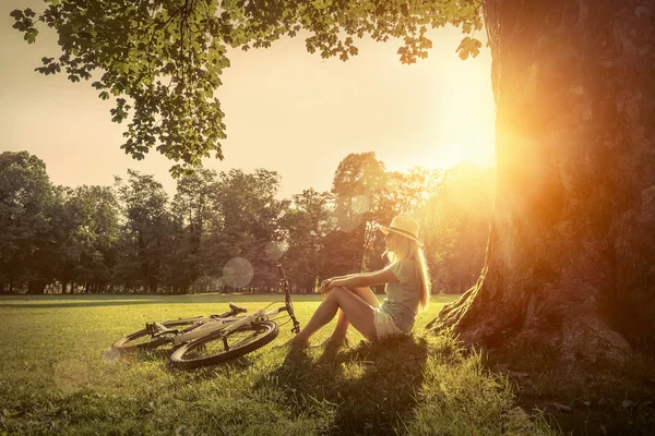 Kvinna sitter nära hennes cykel — Stockfoto