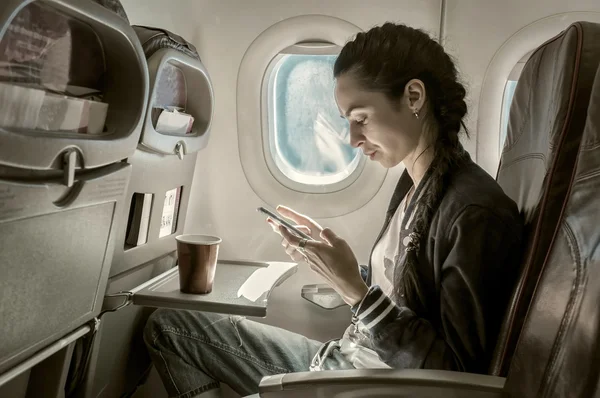 Woman sitting at airplane — Stock Photo, Image