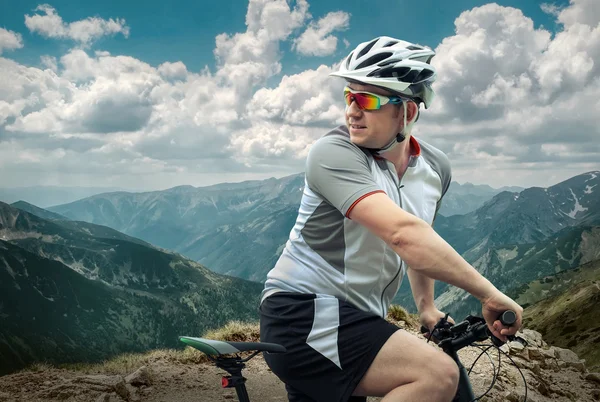 Man with bicycle aroun mountains — Stock Photo, Image