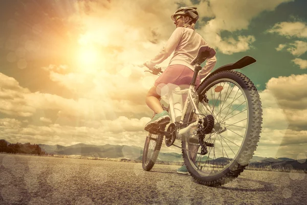 在头盔骑在自行车上的女人 — 图库照片