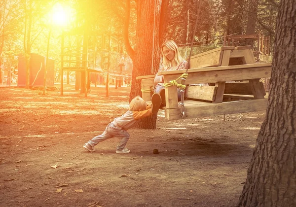 Filho divertido com a mãe no balanço — Fotografia de Stock