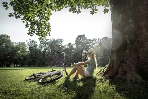 Kvinna sitter nära hennes cykel — Stockfoto
