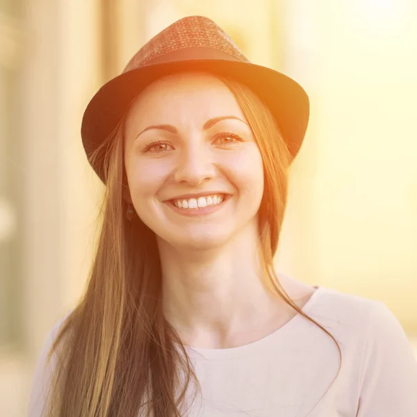 Улыбающаяся женщина в шляпе на улице — стоковое фото