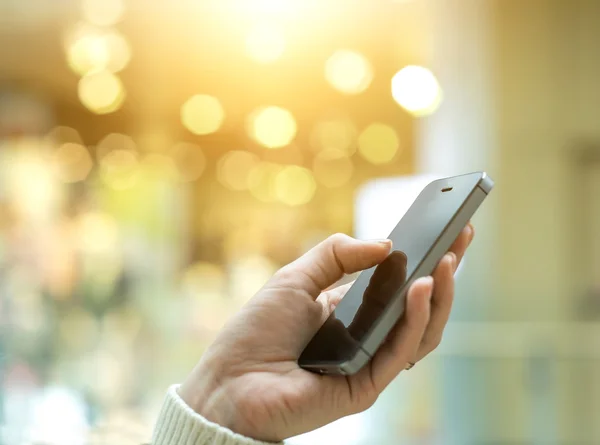 Mão das mulheres usando telefone celular — Fotografia de Stock